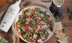 Delicioso carpaccio de higos con jamón serrano, piñones, rúcula y lascas de queso. Un plato ligero y lleno de sabor.