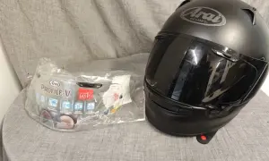 Svart Arai Profile-V hjälm med visir i förpackning. Perfekt för dig som söker en säker och bekväm hjälm.