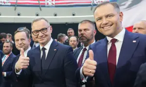 Dwóch mężczyzn w garniturach, jeden z nich pokazuje kciuk w górę. W tle widać napis CPAC Poland. Długość kadencji prezydenta jest tematem dyskusji.