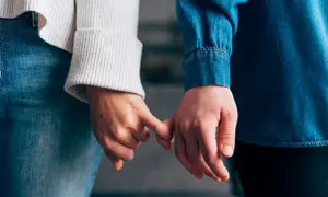 Due mani si stringono con il mignolo, simbolo di un legame che si rinnova dopo un periodo di **lasciarsi e riprendersi psicologia**.