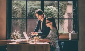 Przykładowa opinia z praktyk: młoda para pracuje przy laptopie, mężczyzna wskazuje coś na ekranie.