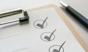 Klemmbrett mit Stift und abgehakten Punkten auf einer Checkliste.