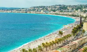 Idealne lazurowe wybrzeże wczasy all inclusive: plaża pełna ludzi, palmy i turkusowe morze.