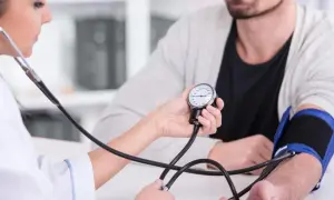 Lekarz mierzy ciśnienie pacjentowi. Dowiedz się, jak szybko obniżyć ciśnienie krwi bez leków w 5 minut.