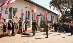 Uroczystość przed budynkiem szkoły z udziałem wojska, uczniów i gości.