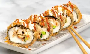Knusprig frittiertes Sushi mit Hühnchen und Gemüse, beträufelt mit Saucen. Ein köstlicher Genuss!