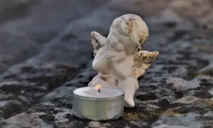 Aniołek z płonącą świecą, symbolizujący poczucie winy po śmierci bliskiej osoby.