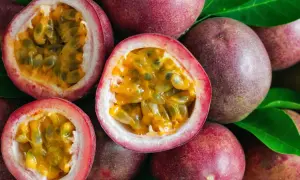 Des fruits de la passion entiers et coupés en deux, révélant leur pulpe juteuse et leurs graines noires. Un délice tropical prêt à être dégusté.