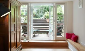 Ein heller Raum mit Holzboden und einer Tür zum Garten. Perfekt, um den **Keller auszubauen** und diesen Ausblick zu genießen.