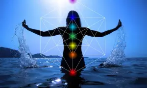 Silueta de persona en el agua con brazos extendidos, salpicando agua. Geometría sagrada y chakras visibles, indicando un posible segundo chakra bloqueado.