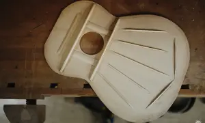 La tapa armónica de una guitarra, hecha de madera de picea, con sus varillas de refuerzo dispuestas para crear un sonido resonante.