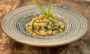 Un crémeux risotto champignon, parsemé de persil frais et garni d'une touche verte. Un délice pour les yeux et les papilles.