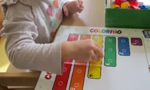 Ein Kind lernt im Kindergarten spielerisch Formen und Farben mit dem Spiel "Colorino".