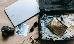 Pakowanie tui bagaż podręczny: laptop, aparat, okulary, sandały i kosmetyczka.