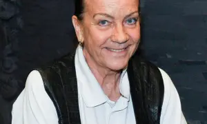 Barbara Burska uśmiecha się, nosząc czarną kamizelkę na białej koszuli.