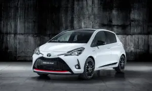 Biały Toyota Yaris GR Sport z czarnym dachem i czerwonymi akcentami, zaparkowany na tle betonowej ściany.