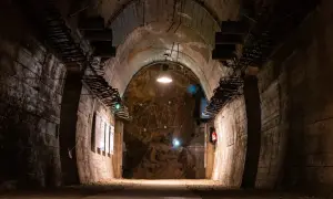 Mroczny tunel w górach sowich, z odsłoniętymi elementami konstrukcyjnymi i oświetleniem.