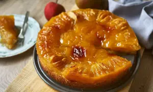 Saftiger Obstkuchen aus der Springform, mit karamellisierten Früchten und einem Stück auf einem Teller. Ein köstliches Obstkuchen Rezept.