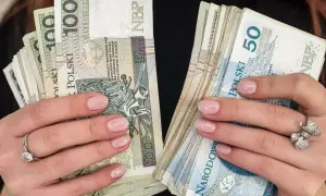 Dłonie z paznokciami pomalowanymi na jasny róż trzymają stosy polskich złotówek. W jednej ręce banknoty 100 zł, w drugiej 50 zł. To pewnie babciowe na drobne wydatki.