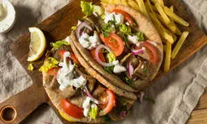 Klasyczny gyros przepis: soczyste mięso, świeże warzywa i sos czosnkowy w picie, podane z chrupiącymi frytkami. Idealny na szybki obiad.