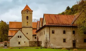 Czerwony Klasztor z wieżą zegarową i pomarańczowymi dachami. Sprawdź cennik zwiedzania tego zabytku.