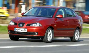 Czerwony Seat Cordoba w ruchu ulicznym, z rozmytym tłem.