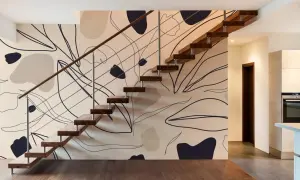 Escalier moderne avec un mur à l'effet peinture, orné de formes abstraites et de lignes organiques dans des tons neutres.