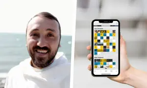 Uśmiechnięty mężczyzna w habicie trzyma smartfon z aplikacją "Niezbędnik katolika czytania na każdy dzień", prezentującą Stary i Nowy Testament.