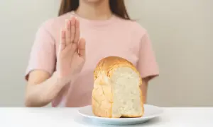 Kobieta odrzuca chleb, symbolizując dietę bezglutenową.