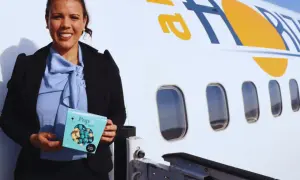 Mujer sonriente con caja de palomitas junto a un avión con el logo "air horizont".