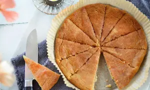 En gyllene, uppskuren kolakaka i en form. Ett recept på kolakakor som ser ljuvligt ut. En ljuslykta och en kniv med en bit kaka.