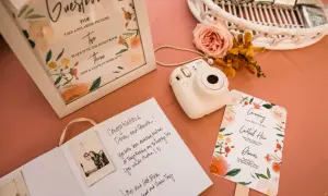 Wpis do księgi gości z polaroidami i życzeniami. Aparat Instax czeka na uwiecznienie chwil.