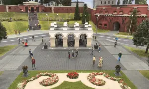 Miniaturowy park w Warszawie z ludzikami spacerującymi po placu przed bramą fortu.