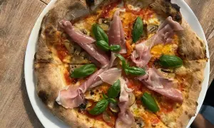 Pyszna pizza z szynką parmeńską i bazylią. Warto sprawdzić ceny w Chorwacji, bo takie smakołyki są warte swojej ceny!