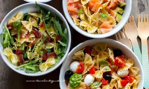 Tre idee per cosa mettere nella pasta fredda: farfalle con rucola e prosciutto, salmone e avocado, o pomodorini, mozzarelline e olive.
