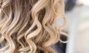 Falujące, blond włosy z subtelnymi, ciemnymi pasemkami, tworzącymi naturalny efekt.