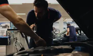 Mecánicos revisan un coche en un taller, asegurándose de que todo esté perfecto cuando se pasa la primera ITV.
