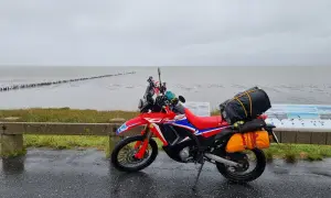 Czerwony motocykl przygotowany na podróż motocyklem nad morze, zapakowany i gotowy do drogi.