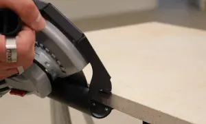 Hand mit Werkzeug schneidet Terrassenplatten. Präzises Arbeiten für die perfekte Verlegung.