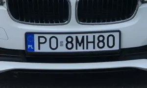 Białe auto z polską tablicą rejestracyjną PO 8MH80.
