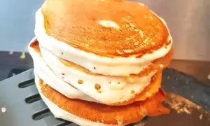 Stos puszystych naleśników proteinowych na łopatce.