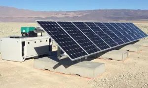 Un impianto fotovoltaico ad isola in un paesaggio arido, con pannelli solari e un'unità di controllo. Le autorizzazioni per questo sistema sono fondamentali per l'energia sostenibile.