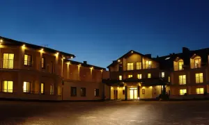 Hotel Rusałka w Okunince nocą, oświetlony, z widokiem na fasadę i balkony.