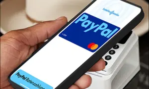 Hand hält Smartphone mit PayPal-Logo und "Kontaktlos bezahlen" für eine schnelle Transaktion. Unten: "PayPal Ratenzahlung".