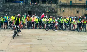 Grupa rowerzystów w kamizelkach odblaskowych przed katedrą. Szukasz najlepszych tras pielgrzymkowych w Polsce dla rowerzystów?