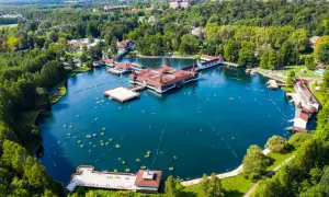 Termalne jezioro z architekturą w stylu zamkowym, otoczone zielenią. To jedno z najpiękniejszych miejsc nad Balatonem, gdzie można odpocząć i skorzystać z kąpieli.