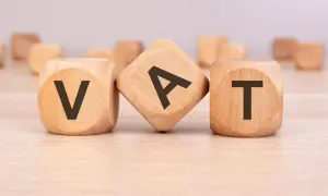 Drewniane kostki z literami V, A, T. Symbolizują fakturę bez VAT, czyli transakcję zwolnioną z podatku.