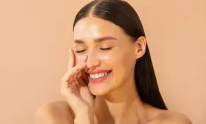 Une femme rayonnante sourit, découvrant les bienfaits du cuivre sur les cheveux. Sa peau lumineuse et ses cheveux brillants témoignent de sa beauté naturelle.