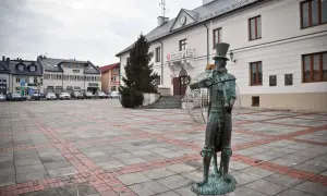 Pomnik chrząszcza w Szczebrzeszynie, jedna z głównych atrakcji miasta, na tle ratusza i placu.
