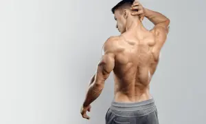 Uomo con muscoli spalle e schiena scolpiti, posa di profilo con mano dietro la nuca.